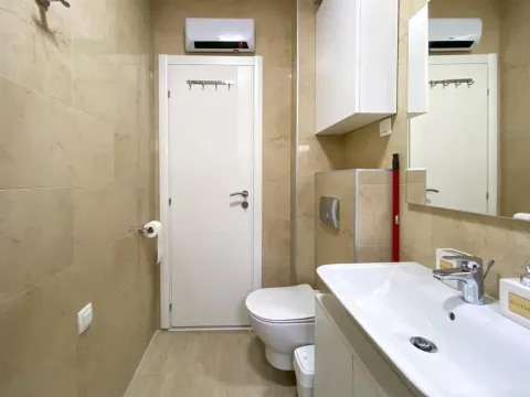Small tiled bathroom with a sink and a toilet. - image 3