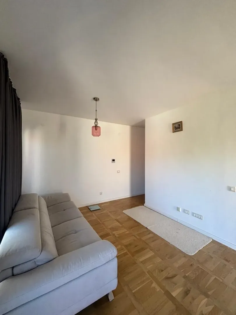 Living room with a sofa and parquet flooring.