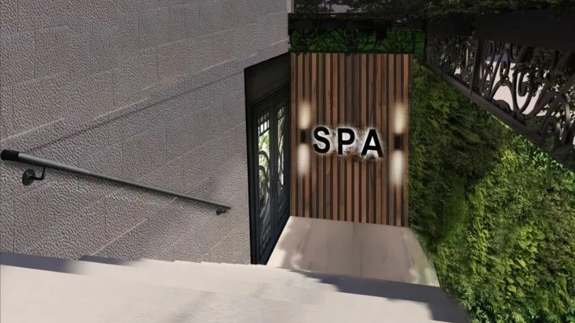 Ulaz u spa centar sa natpisom na zidu i stepeništem.