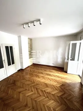 Prazna prostorija sa drvenim parketom i belim zidovima. - image 4