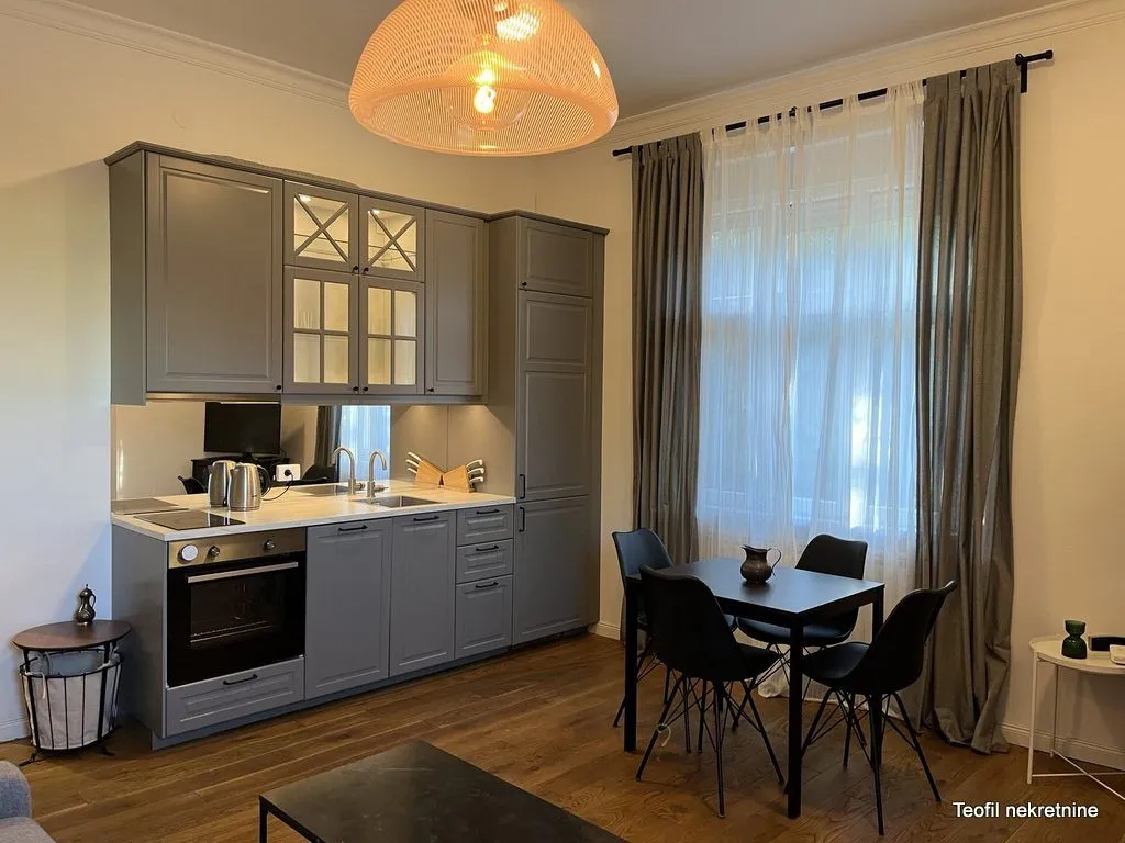 Kitchen with grey cabinets and a dining table next to the window.