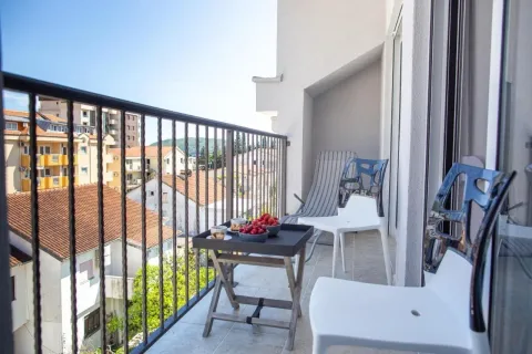 Furnished balcony with a table, chairs, and city view. - image 7
