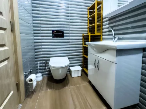 Manje kupatilo sa umivaonikom, WC šoljom i drvenom policom. - image 5