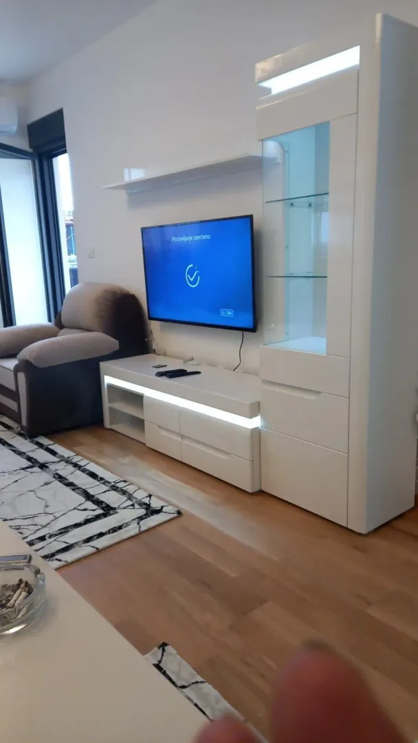 Living room featuring a modern white TV unit and television.