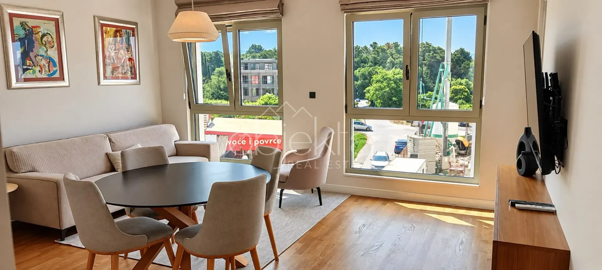 Living room with a dining area and large windows with a view of the surroundings.