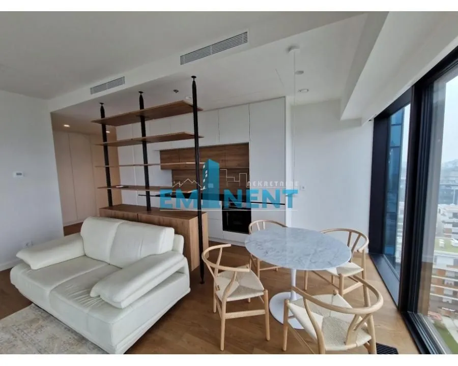 Living room with a sofa, dining table, and kitchen units.