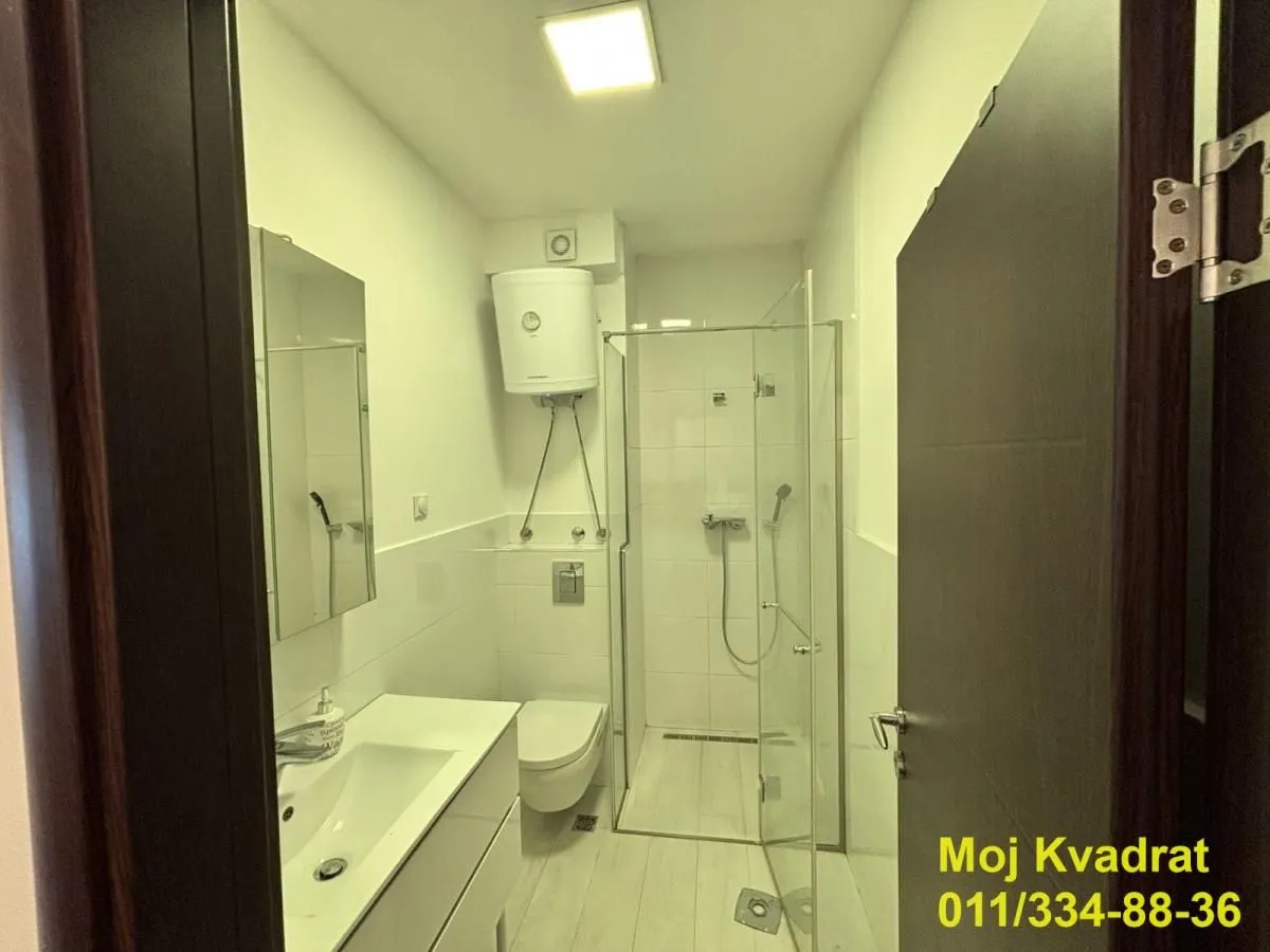 Manje kupatilo sa tuš kabinom, umivaonikom i wc šoljom.