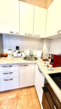 Small kitchen with light-colored cabinets and a sink. - image 6