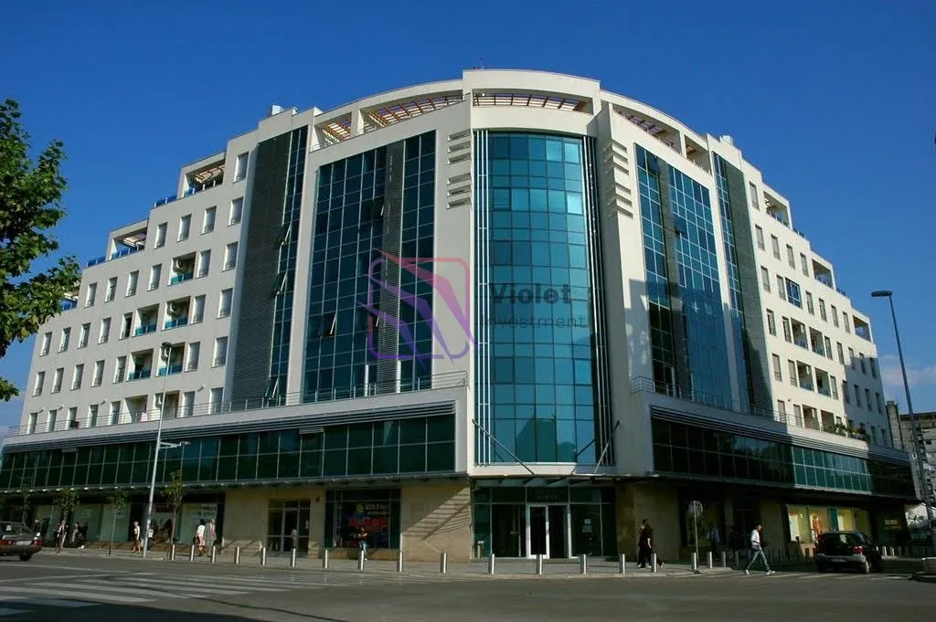 Exterior view of a modern residential and commercial building with a glass facade.