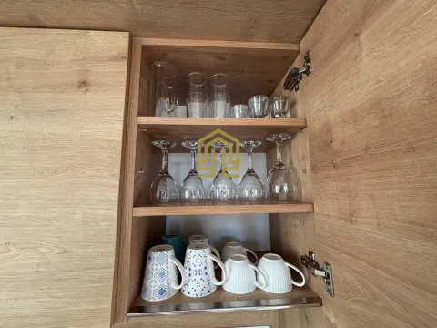 Open kitchen cabinet with neatly arranged glasses and mugs. - image 14