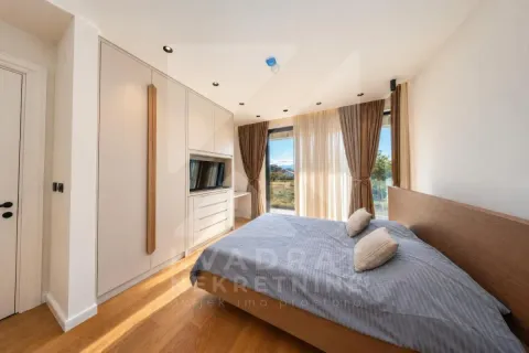 Modern bedroom with a double bed, built-in wardrobe, and large window. - image 10