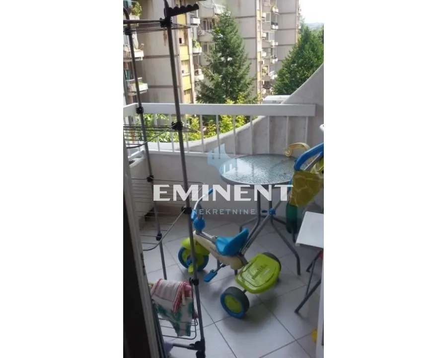 Pogled na namešten balkon sa stolom i dečjom igračkom.
