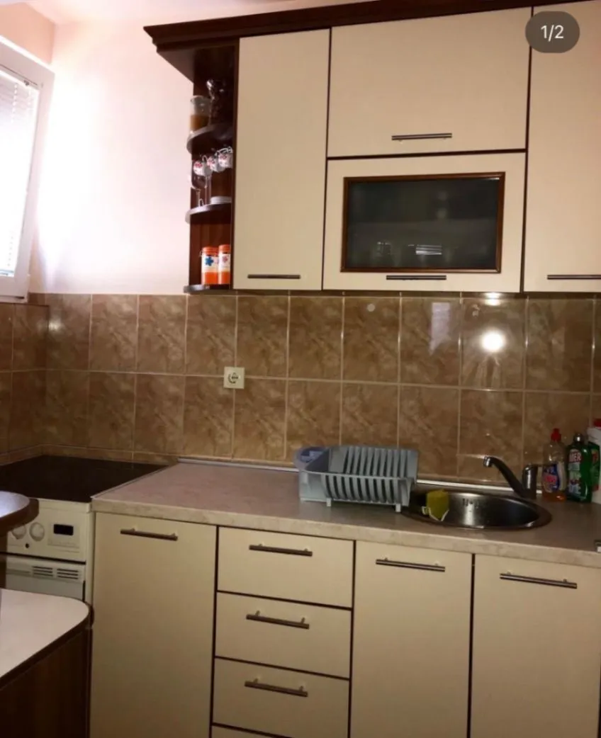 Small kitchen with light-colored cabinets and ceramic wall tiles.