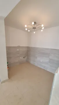 Prazna prostorija sa keramičkim pločicama na zidu i plafonjerom. - image 11