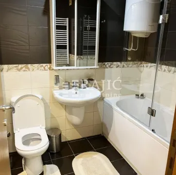 Fully equipped bathroom with a bathtub, washbasin, and toilet. - image 12