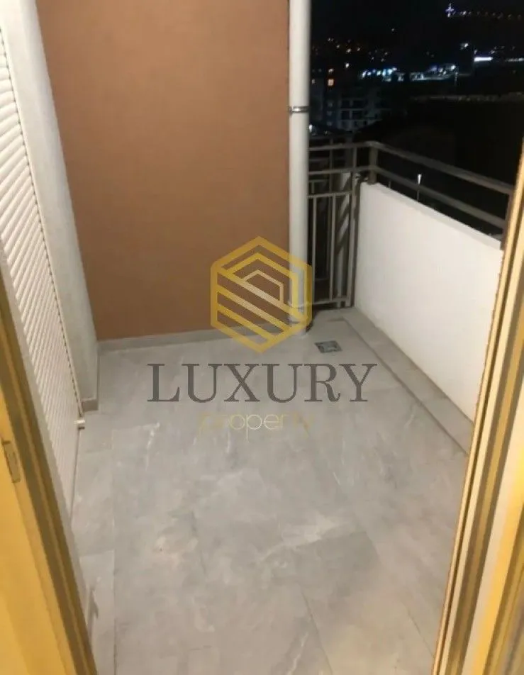 Smaller enclosed balcony with tiled floor and railing.