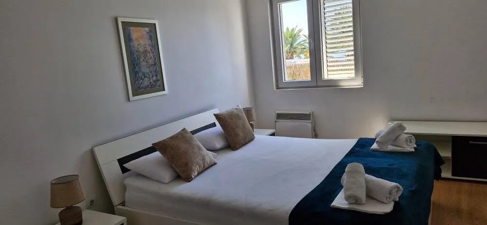 A bedroom with a large double bed and a window.