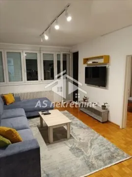 Living room with a sofa, coffee table, and TV. - image 2