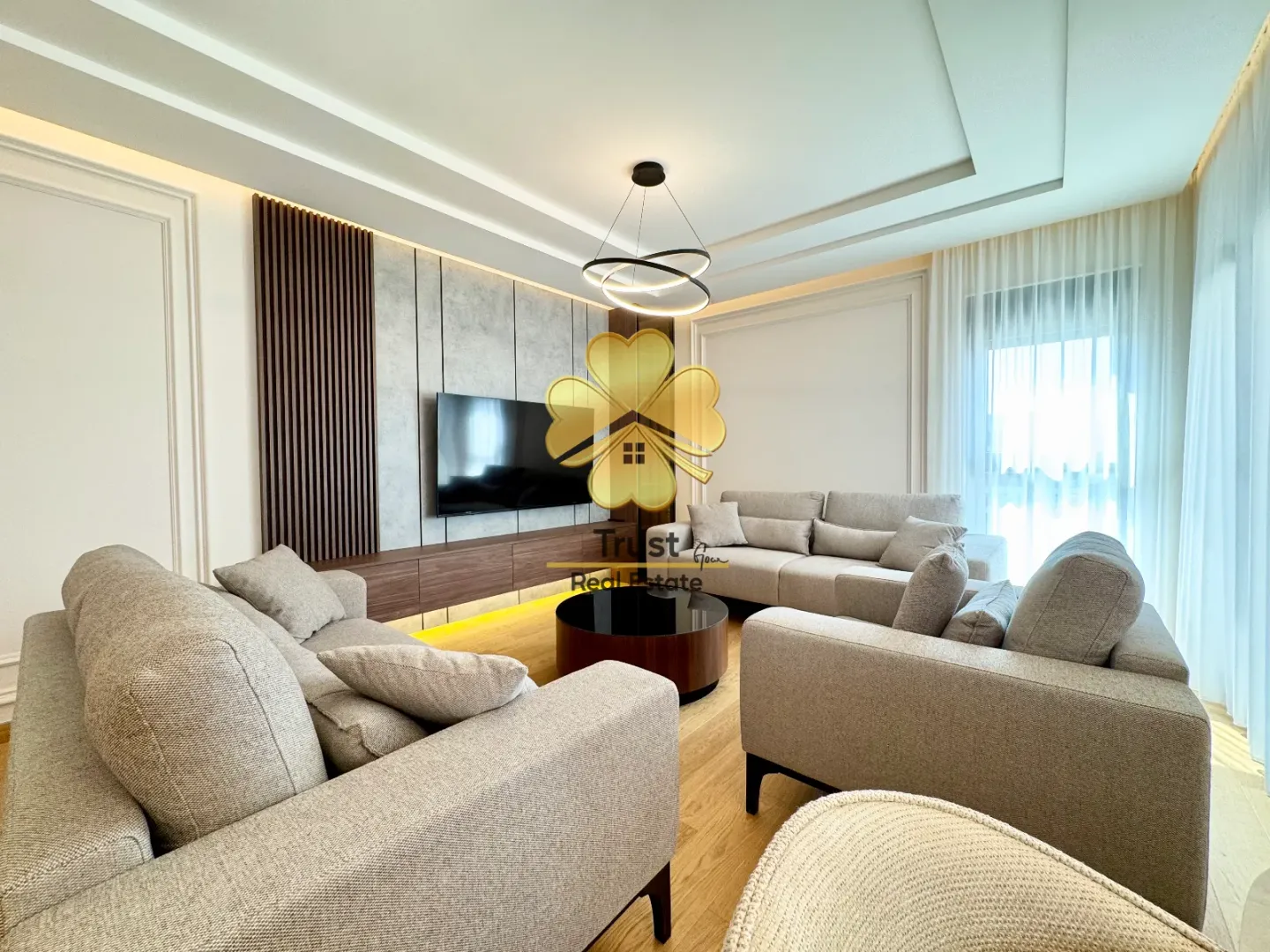 Modern and bright living room with a sofa set and a TV.