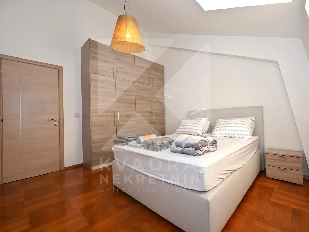 Bedroom with a double bed, large wardrobe, and wooden flooring.