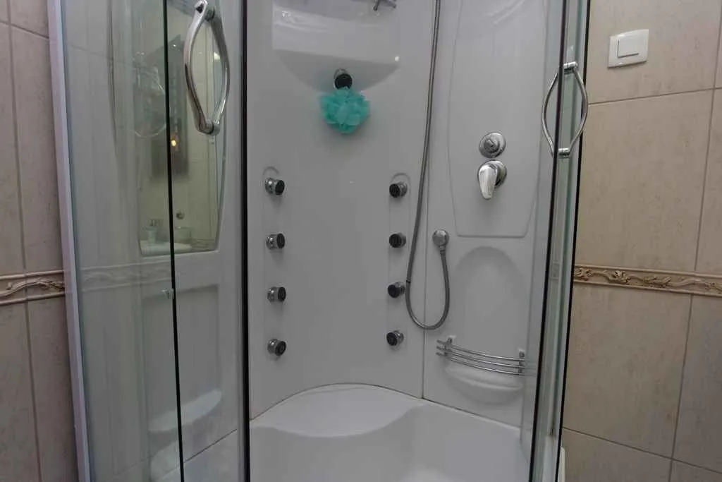 A modern shower cabin with massage jets in a bathroom.