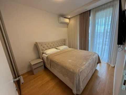 Uređena spavaća soba sa bračnim krevetom, noćnim stočićem i klima uređajem. - image 6
