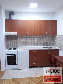 Manja kuhinja sa drvenim elementima, šporetom i sudoperom. - image 3