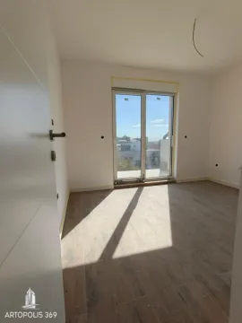 Prazna neopremljena prostorija sa drvenim podom i balkonskim vratima. - image 4