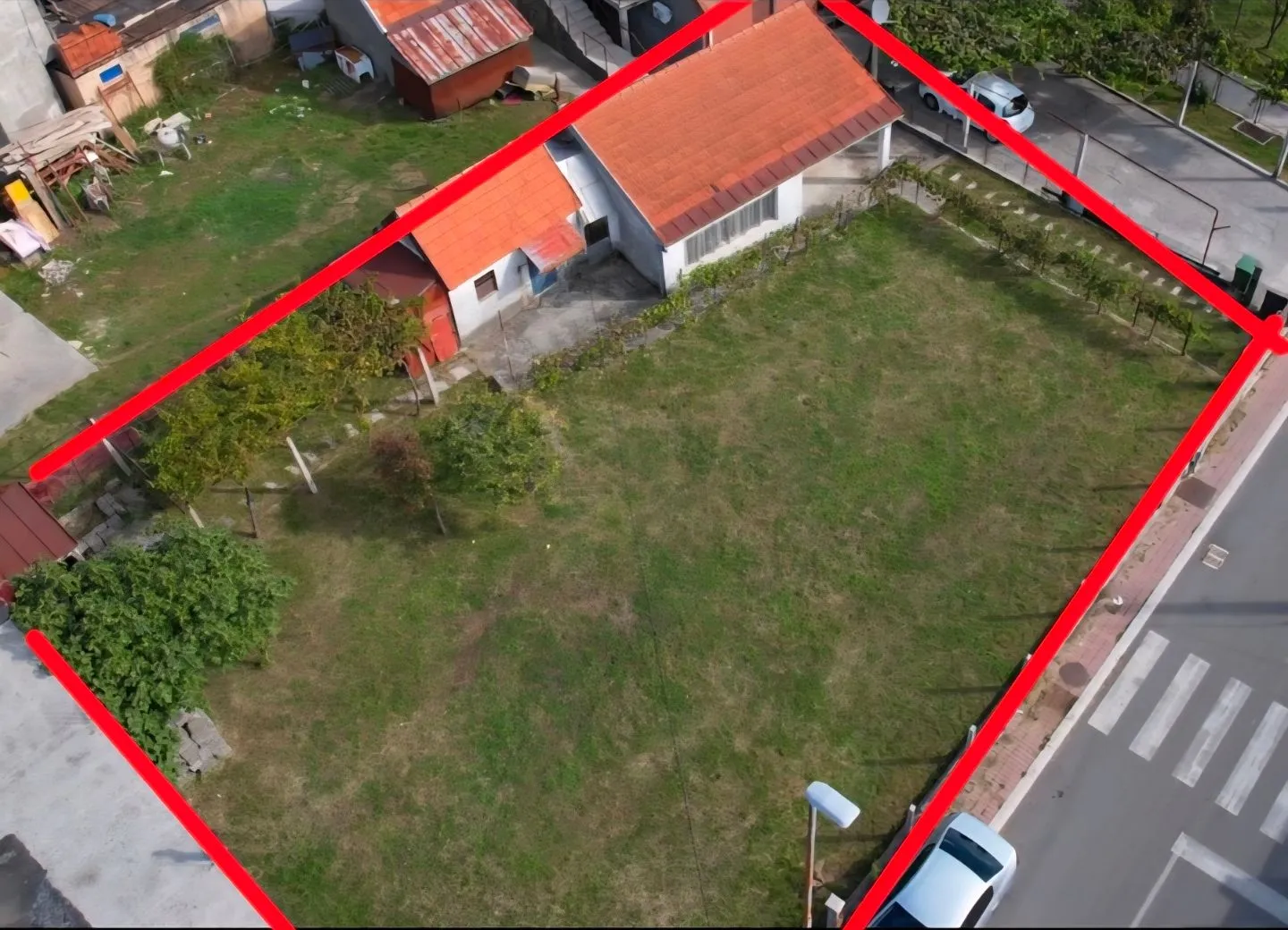 Vazdušni pogled na plac sa kućom, crvenim okvirom i prilaznim putem.
