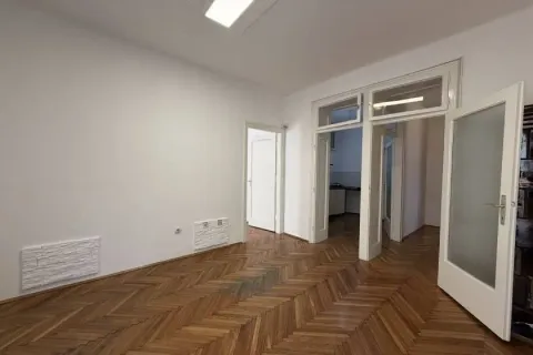 Empty room with parquet flooring and white walls. - image 4
