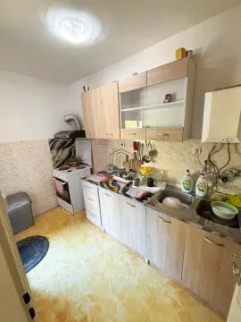 Manja kuhinja sa drvenim elementima, sudoperom i šporetom. - image 12