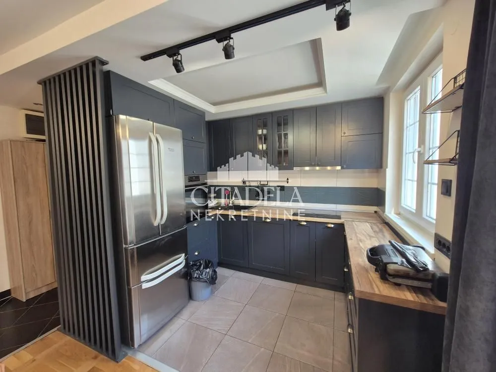 Modern kitchen with dark cabinets and a large refrigerator.
