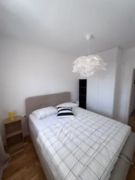 Bright and tidy bedroom with a double bed, white wardrobe, and modern ceiling lamp. - image 6