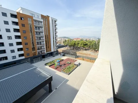 View from the balcony overlooking the residential building and courtyard with a children's playground. - image 11