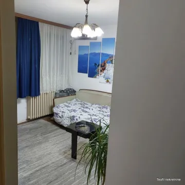 Nameštena spavaća soba sa krevetom i dekorativnim slikama na zidu. - image 2