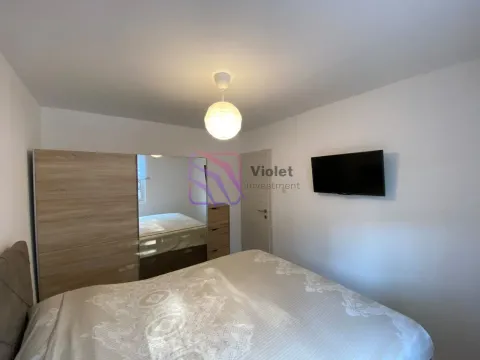 Bedroom with a double bed, wardrobe, and wall-mounted television. - image 7