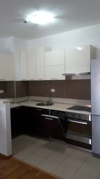 Moderna kuhinja sa bijelim visećim elementima i tamnim donjim elementima. - image 3