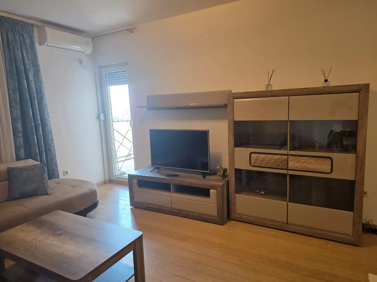 Living room with a sofa, TV, and access to the terrace.