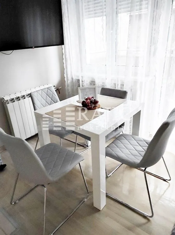 Dining area with a table and grey chairs near the window.