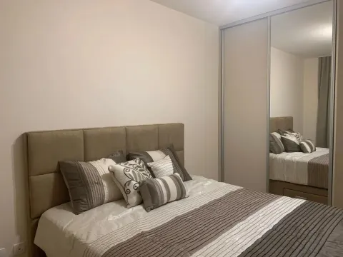 Furnished bedroom with a double bed and a fitted mirrored wardrobe. - image 3