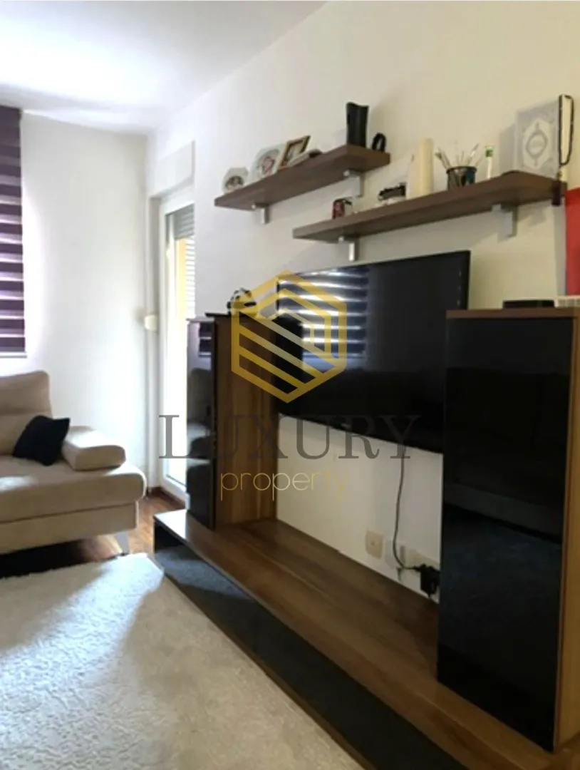 Living room with a TV unit and shelves.