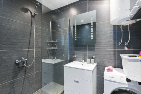 Moderno opremljeno kupatilo sa tuš kabinom, umivaonikom i veš mašinom. - image 11