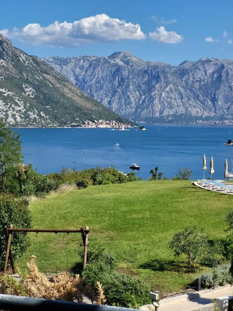 Pogled na zaliv i planine sa uređene zelene terase.