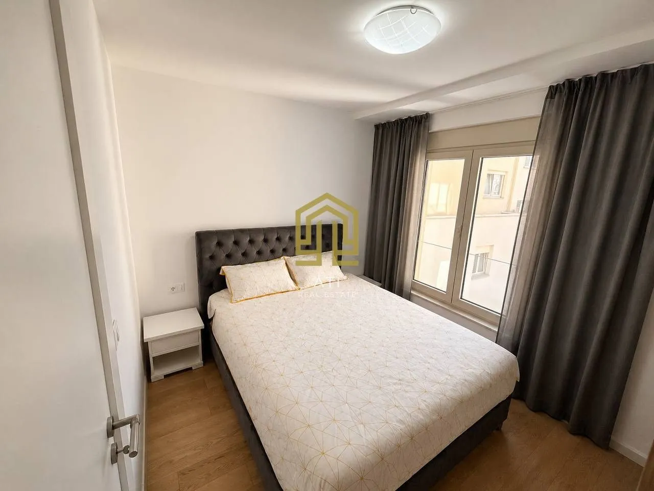 Furnished bedroom with a double bed and a window.