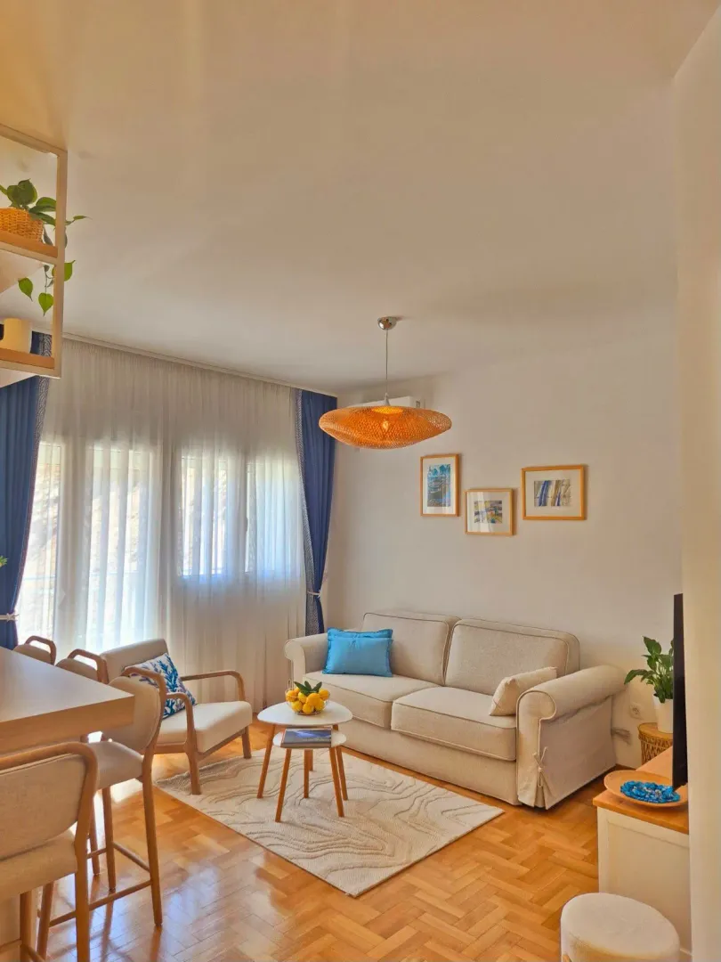 Bright living room with a sofa, coffee table, and dining area.