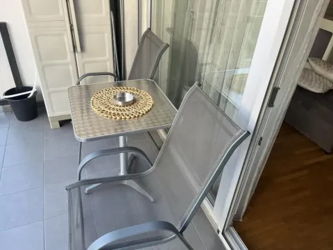 Manji namešteni balkon sa stolom i dve stolice. - image 4