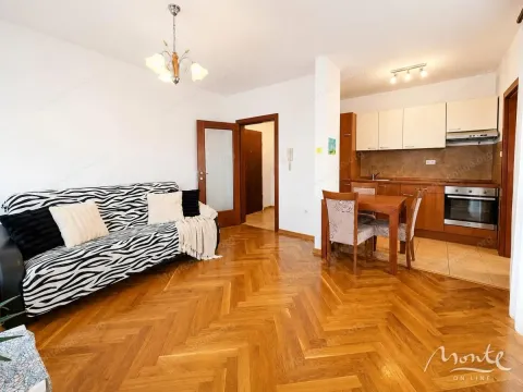 Dnevni boravak sa trosjedom, trpezarijskim stolom i kuhinjom u pozadini. - image 3