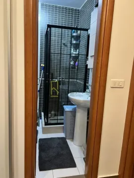 Pogled na uređeno kupatilo sa tuš kabinom kroz otvoren vrata. - image 6