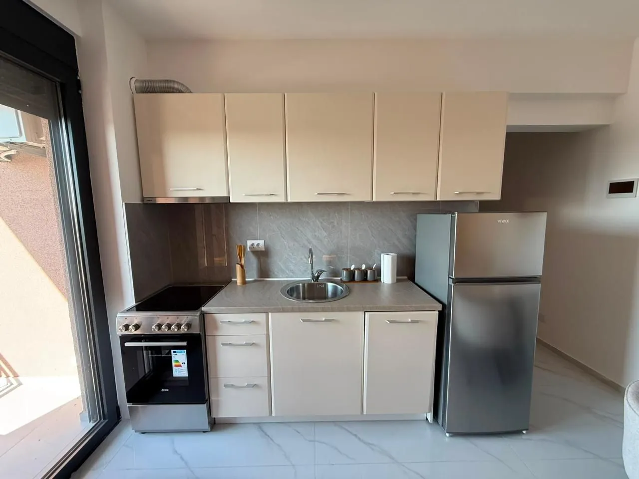 Kitchen equipped with cabinetry, stove, and refrigerator.