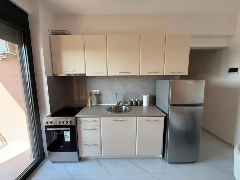 Kitchen equipped with cabinetry, stove, and refrigerator. - image 5